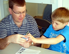 father teaching autistic son photo